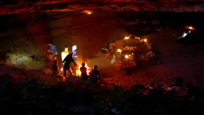 groupe de personnes installés dans un campement pour la nuit, dans une grotte