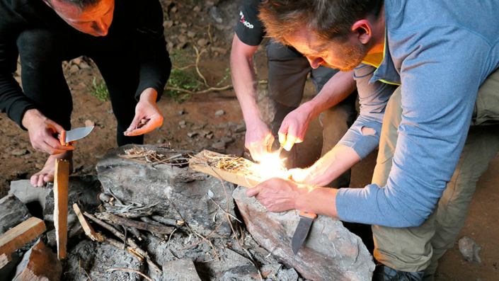 Groupe de personnes allumant un feu lors d'une stage de survie